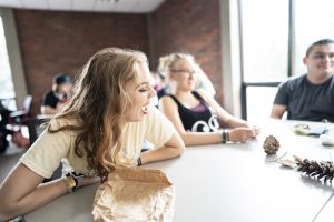 Photo of Grace P sitting at a table laughing