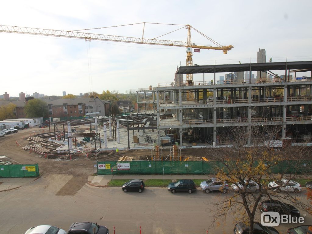 Construction site showing the structural steel framework between the two wings, the six lobby columns (up to the second-floor level) and the door frame for the main entrance.