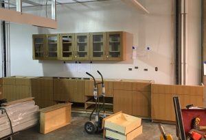 Installation is underway for the casework in a basement lab.