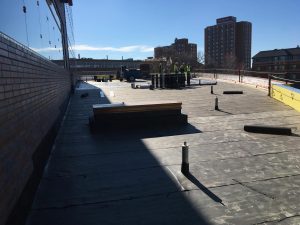 Crews install waterproofing to prepare the green roof on top of the flexible classroom space.