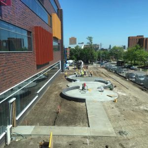 Concrete walkways are under construction to connect the outdoor seating area east of the building. 