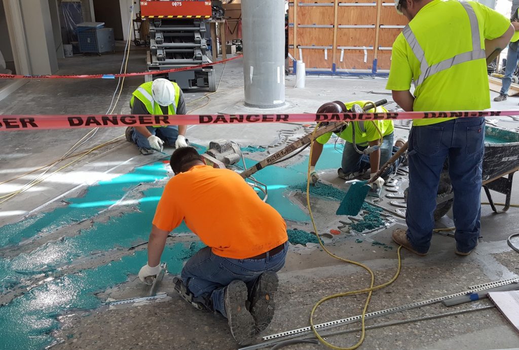 Crews pour the terrazzo lobby floor