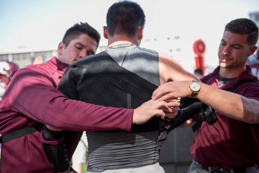 Athletic training staff members assist an Augsburg football player