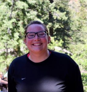 Amanda Vetsch standing in front of green trees